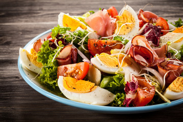 Boiled eggs with smoked ham and vegetables