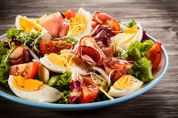 Boiled eggs with smoked ham and vegetables