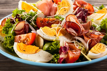Boiled eggs with smoked ham and vegetables