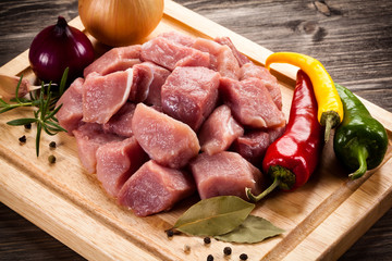 Raw pork chops on cutting board and vegetables