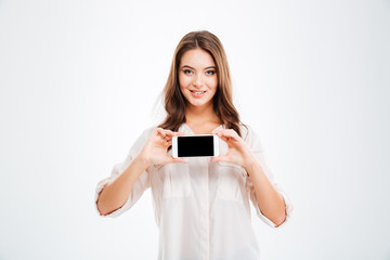 Naklejka premium Smiling woman showing blank smartphone screen isolated on white background