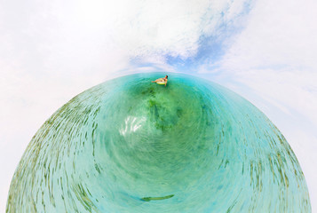 Girl in inflatable ring floating in the azure sea