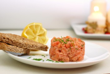 Raw salmon tartar with roasted bread and lemon