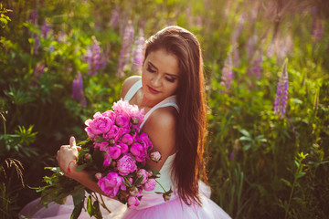 beautiful brunette holds a large bouquet of flowers