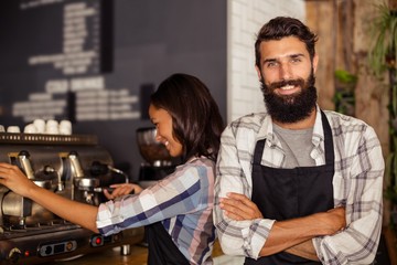 Portrait of waiter standing with arms crossed 