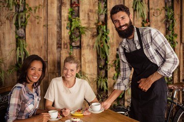 Waiter serving a cup of coffee to customer