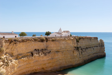 Naklejka premium Chapel of Nossa Senhora da Rocha on top of the spectacular cliffs on Nova Beach. Algarve