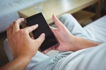 Mid section of man checking his mobile phone