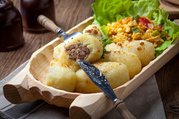 Dumplings with meat in a wooden bowl.