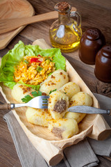 Dumplings with meat in a wooden bowl.