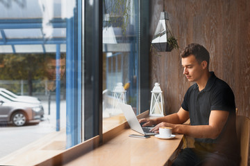 young businessman working at a modern cafe on the foreground