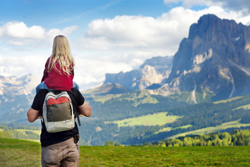 Father and his little daughter admiring a view of Seiser Alm, the largest high altitude Alpine...
