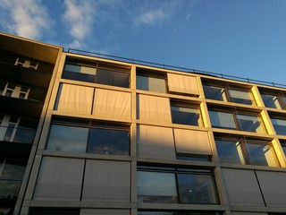 Sonnenschutz an großen Fenstern eines modernen weißen Bürogebäude im Licht der Abendsonne am...