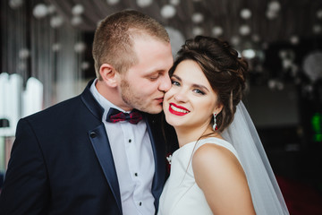 Wedding day. Groom kisses smiling and happy bride after wedding ceremony. Romantic momment