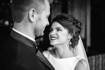 Wedding. Wedding day. Bride and groom after wedding ceremony look at each other and laughing. Close-up. Black and white.
