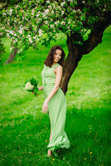 beautiful young woman walking in a green garden