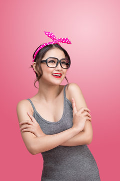 Fashion portrait of asian girl with sunglasses standing on pink