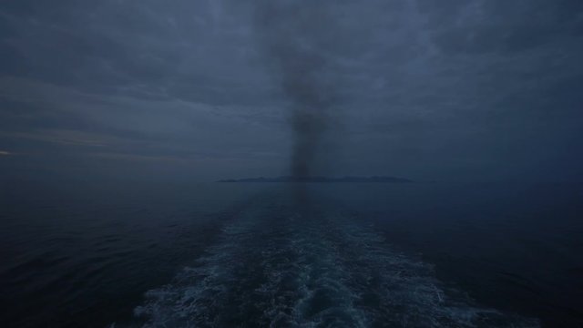 4k video of sea wave behind large cruise ship. Hazy due to pollution smoke from smoke stacks and engine. Horizon in distance