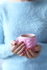 Woman hands holding cup of coffee on wooden table