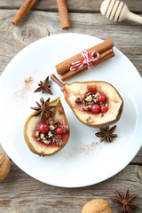 Baked pears with honey, walnuts and cranberries on grey wooden t