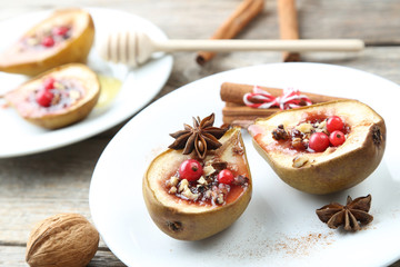 Baked pears with honey, walnuts and cranberries on grey wooden t