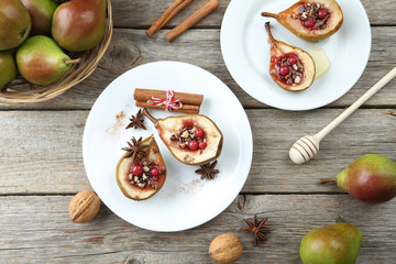 Baked pears with honey, walnuts and cranberries on grey wooden t