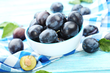 Tasty and ripe plums on blue wooden table