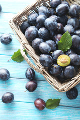 Tasty and ripe plums on blue wooden table