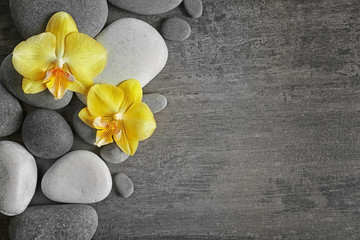 Obraz na płótnie Canvas Spa stones with orchid flowers, top view
