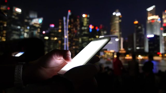 Woman Hands Using Mobile Phone Against Night City Skyline