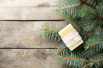 Piece of coniferous soap and branches on wooden background