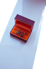 Cuff-links with original design stand in the brown box