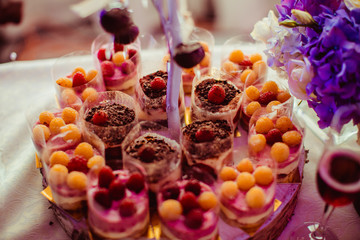 Cold sweet desserts with red and yellow fruits stand on the plat