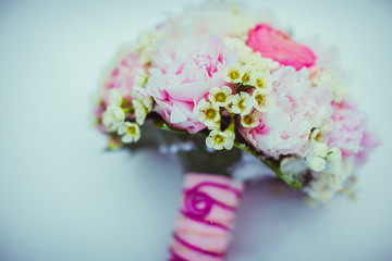 A closeup of tiny white flowers put in pink wedding bouquet