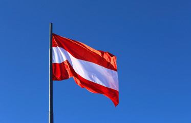 great Austrian flag waving in the blue cloudless sky