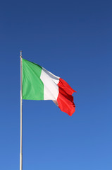 big Italian flag waving in the blue sky