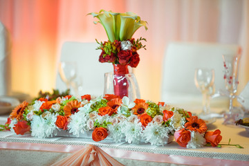 Wedding dinner table decorated with orange and white roses