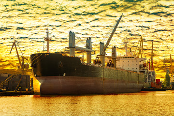 Cargo ship at sunset in port of Gdansk, Poland.
