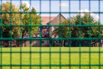 Green fence with house in the background for concept use