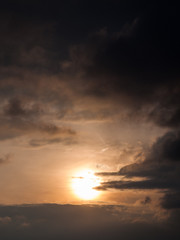 hazy sun behind cloud formations