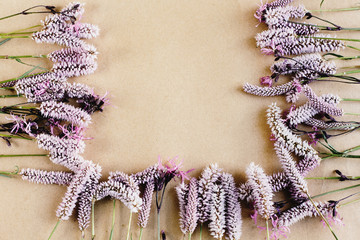 beautiful natural frame with pink flowers on craft background, s