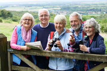 Group Of Senior Friends Hiking In Countryside - obrazy, fototapety, plakaty