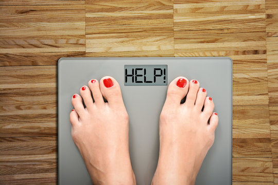 Time To Start A Diet With Women’s Feet On A Scale, Saying HELP