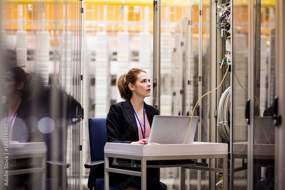 Wall mural technician using laptop while analyzing server