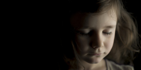 Portrait of a young girl on black background