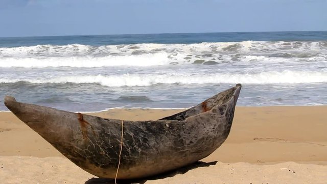 Traditional wooden hand made African / Malagasy fishing boat - piroga on the sandy beach of Indian ocean in Madagascar, Africa