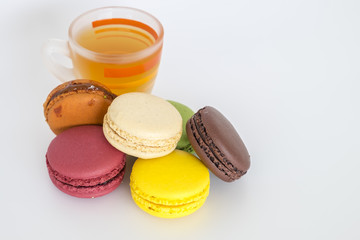 Cap of tea with traditional french colorful macarons on white background.