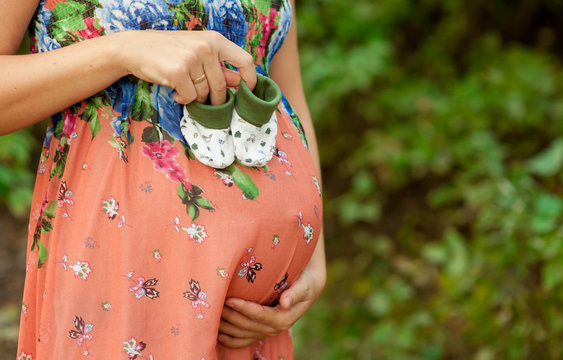 Pregnant woman holding booties