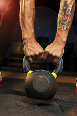 Cropped shot of young man holding kettlebell.