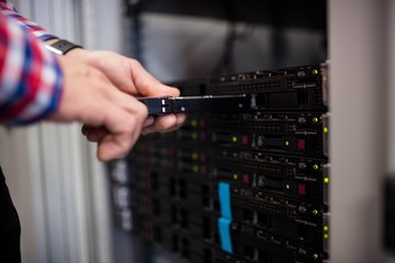 Technician inserting a hard disk drive into a blade server